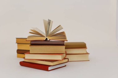 Dünyanın en ünlü yazarlarından okumaya hazır güzel bir kitap seti kütüphane arka planındaki ahşap masanın üzerinde kitap ve gözlük yığını. eğitim ve bilgi kavramı, kütüphane, okul