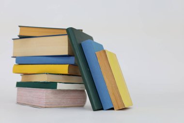 Beyaz arka planda izole edilmiş renkli kitapların yığını okula geri dönüyor.