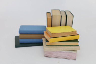 Beyaz arka plan üzerine bir yığın kitap, dünyanın en ünlü yazarlarının okumaya hazır güzel kitapları, kütüphane arkaplanının önündeki ahşap masanın üzerinde bir yığın kitap ve gözlük. eğitim ve bilgi kavramı, kütüphane, okul