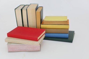 Dünyanın en ünlü yazarlarından okumaya hazır güzel bir kitap seti kütüphane arka planındaki ahşap masanın üzerinde kitap ve gözlük yığını. eğitim ve bilgi kavramı, kütüphane, okul