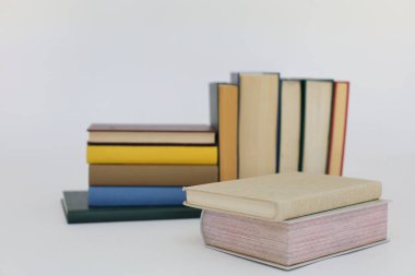 Dünyanın en ünlü yazarlarından okumaya hazır güzel bir kitap seti kütüphane arka planındaki ahşap masanın üzerinde kitap ve gözlük yığını. eğitim ve bilgi kavramı, kütüphane, okul