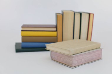 Beyaz arka plan üzerine bir yığın kitap, dünyanın en ünlü yazarlarının okumaya hazır güzel kitapları, kütüphane arkaplanının önündeki ahşap masanın üzerinde bir yığın kitap ve gözlük. eğitim ve bilgi kavramı, kütüphane, okul