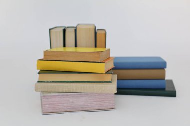 Beyaz arka plan üzerine bir yığın kitap, dünyanın en ünlü yazarlarının okumaya hazır güzel kitapları, kütüphane arkaplanının önündeki ahşap masanın üzerinde bir yığın kitap ve gözlük. eğitim ve bilgi kavramı, kütüphane, okul