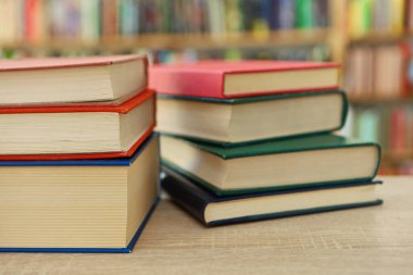 Ahşap arka planda kütüphanede bir yığın kitap