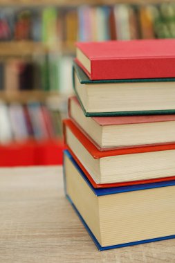 Ahşap arkaplana karşı masadaki kitap yığını