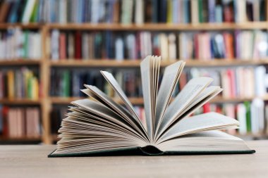 book with a stack of books on a wooden table