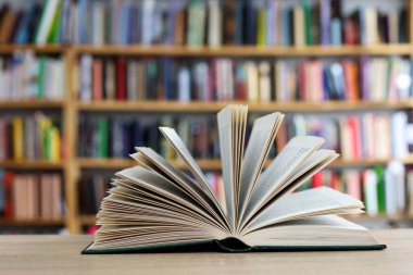 Kütüphanedeki ahşap masada yığınla kitap. Metin için boşluk