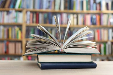 stack of books and eyeglasses on table in library