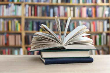 Kütüphanedeki masanın üzerinde kitap yığını