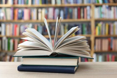 Kütüphanedeki masanın üzerinde kitap yığını