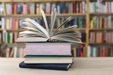 Kütüphanedeki masanın üzerinde kitap yığını