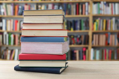 Kütüphanedeki masanın üzerinde kitap yığını