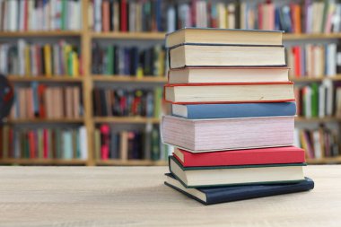 Ahşap masanın önünde kitap yığını