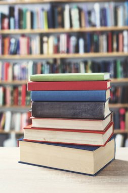 Kütüphanedeki masanın üzerinde kitap yığını