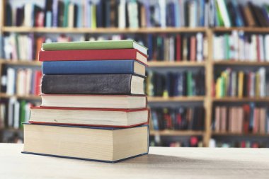Kütüphanedeki masanın üzerinde kitap yığını
