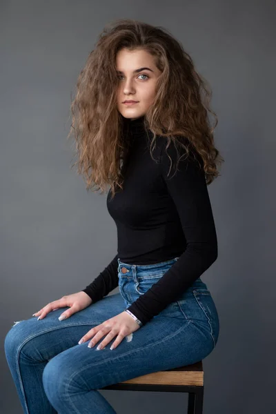 Sensual Girl Curly Hair Sitting High Chair Grey Background Looking 로열티 프리 스톡 이미지