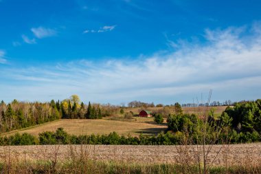 Nisan ayında kırmızı ahırı olan Wisconsin tarım arazisi, yatay
