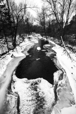 Wisconsin 'in merkezinde kısmen donmuş Yeni Ahşap Nehir siyah beyaz ve dikey