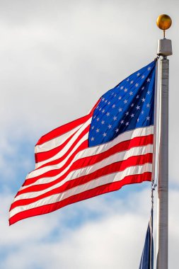 Arka planda bulutlarla dalgalanan Amerikan bayrağı, vrtic