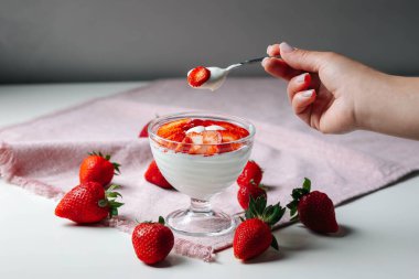 Çilekli taze süt ürünleri ve odak noktasında Yunan yoğurdu, basitlik, sağlık ve tazelik çağrıştırıyor.