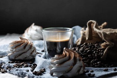 Siyah arkaplanda kahve çekirdekleri olan bir bardak buzlu kahve. Kopyalama alanı olan üst görünüm.