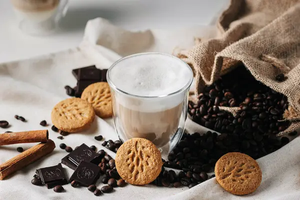 Bir fincan sıcak çikolata, kurabiye ve tarçın çubukları.