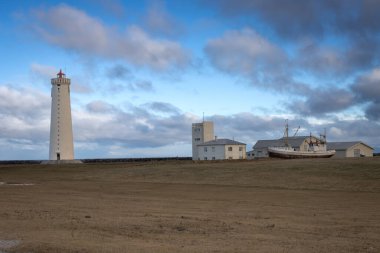 Gardskagaviti - İzlanda 'nın en uzun deniz feneri ve sağ tarafındaki müze. Eski deniz fenerinin yakınındaki bir çayırda. Beyaz bulutlu mavi gökyüzü. Sudurnesjabear, İzlanda