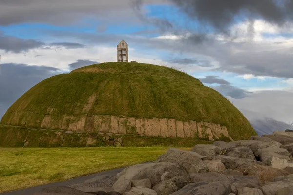 Thufa Hill yerel folklora dayanarak meditasyon ve sükunet için bir yerdir. Yeşil çimlerle kaplı. Yağmurlu bulutlu gökyüzü. Grandi, Reykjavik Limanı, İzlanda