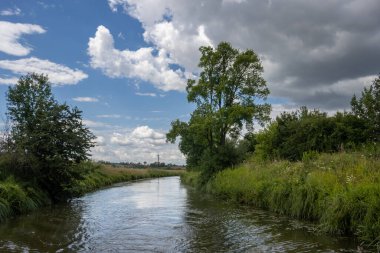 Bata 'nın Morava bölgesi ile Slovakya arasında inşa ettiği kanal. Güzergahı çevreleyen güzel yeşillikler, ağaçlar, çalılar, çimenler ve çiçekler. Beyaz bulutlu mavi gökyüzü. Bata Kanalı, Çek ve Slovakya Cumhuriyeti