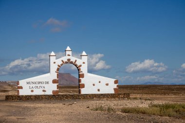 Adanın her belediyesine giriş kapısı vardır. Bu kapı Oliva Belediyesi (Municipio de la Oliva) içindir. Yolun kenarında inşa edilmiş. Arka plandaki dağ. Fuerteventura, Kanarya Adaları