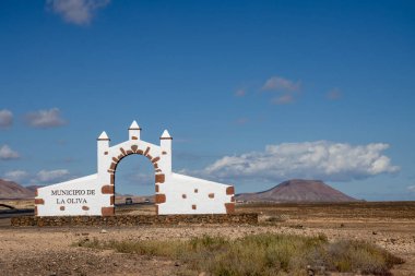 Adanın her belediyesine giriş kapısı vardır. Bu kapı Oliva Belediyesi (Municipio de la Oliva) içindir. Yolun kenarında inşa edilmiş. Arka plandaki dağ. Fuerteventura, Kanarya Adaları