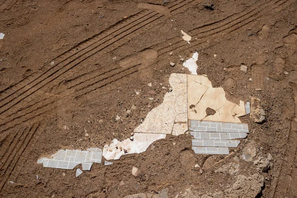 Soil with footprints, trails and broken pieces of ceramic tiles, looking like an abstract map. Fuerteventura, Canary Islands, Spain.