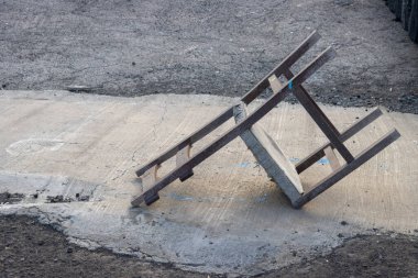 Eski ahşap sandalye, sokağın yukarısına düşmüş. Beton ve aspahalt arka plan. El Cotillo, Fuerteventura, Kanarya Adaları, İspanya.