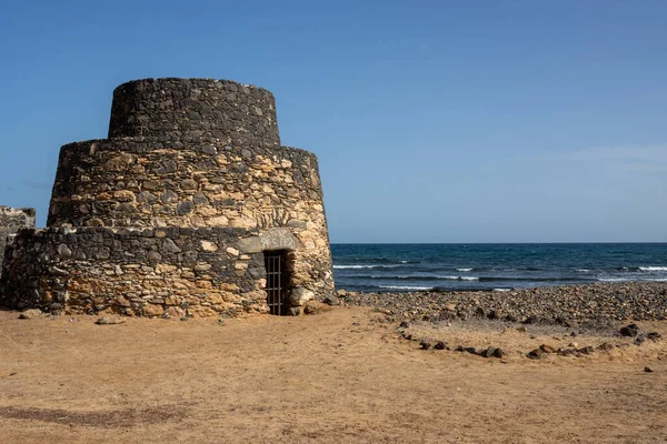 stock image Former limestone factory, today a sightseeing place, located on the coast of Atlantic ocean. Bright blue sky. Hornos de Cal de la Guirra, La Guirra Beach, Fuerteventura, Canary Islands, Spain