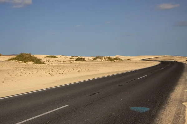 Good quality of the road through the desert. Sand of the dunes on both sides of the roads. No people in the winter season. Parque natural Dunas de Corralejo, Fuerteventura, Canary Islands, Spain.