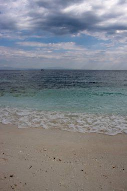 Beyaz mermer parçalarıyla kaplı bir sahilde kıyı şeridi ve turkuaz Trakya denizi manzarası. Eylül 'de bulutlu bir gökyüzü. Porto Vathy, Thassos (Thasos), Yunanistan