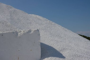 Adanın kıyısında mermer madenciliği. Parlak beyaz mermer bloklar halinde ya da taş gibi parçalar halinde. Mavi gökyüzü. Porto Vathy, Thassos (Thasos), Yunanistan.