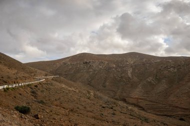 Adanın merkezindeki yüksek dağlar. Yoğun bulutlar. Yol çizgisi. Mirador de las Penitas, Betancuria, Fuerteventura, Kanarya Adaları, İspanya. Mirador de las Penitas