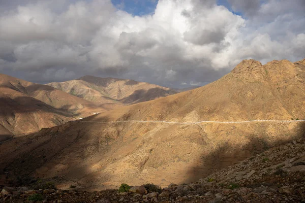 stock image High mountains in the centre of the island, with a small line of a road. Intense clouds. Mirador del Risco de las Penas, Betancuria, Fuerteventura, Canary Islands, Spain.