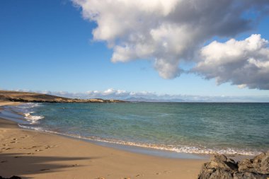 Atlantik Okyanusu 'nun kumsalında, kış mevsiminde insan olmaz. Parlak mavi gökyüzü. Turkuaz su. Doğal park Dunas de Corralejo, Fuerteventura, İspanya.
