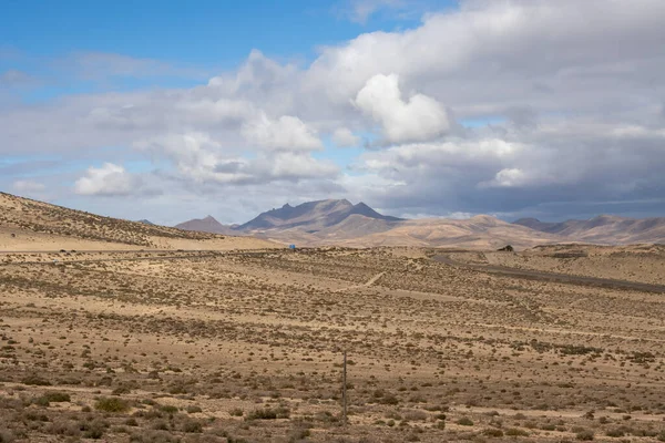Area in the south of the island, with hills and deserted land. Blue sky with white clouds. Costa Calma, Fuerteventura, Canary Islands, Spain.