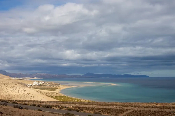 Area in the south of the island, with hills and deserted land and Atlantic ocean. Blue sky with white clouds. Costa Calma, Fuerteventura, Canary Islands, Spain.