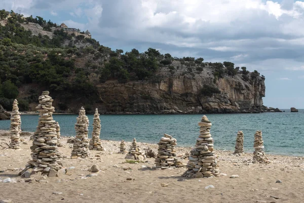 Plaj çakıl taşlarından yapılmış kuleler bu plajın spesiyalitesi, bir çoğunun olduğu yer. Trakya denizi sakin. Livadi Plajı, Thassos (Tassos), Yunanistan.