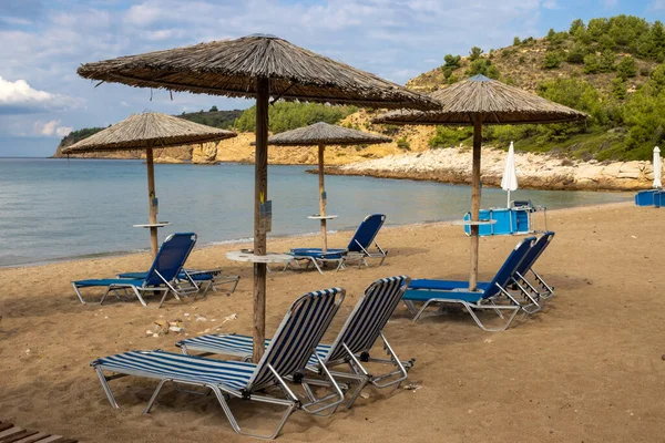 Calm morning after a night rain in the south of the island. Beach still empty, but all the deck chairs and umbrellas are ready. Island Thassos (Tassos), Greece.
