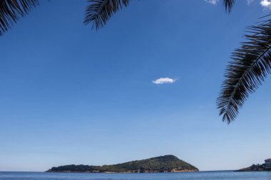 Denizin küçük dalgalı mavi rengi. Küçük ada Nisida Koynira doğuda. Mavi gökyüzü. Doğu Thassos (Tassos), Yunanistan