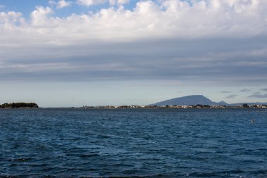 Akdeniz 'de (Tyrhenian) akşam erken saatlerde. Baharda bulutlu bir gökyüzü. Aegadian Adaları 'nın (Isole Egadi) silueti. Marsala, Sicilya, İtalya.