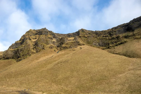 Stock image Dramatic and wild beauty of the mountains and tranquil pastures, covered with grass, moss and lichen. Cloudy sky in the autumn. Vik, Iceland.