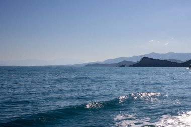 Korfu 'dan Erikousa adasına sürat teknesiyle yolculuk. İyon (Akdeniz) denizinin sakin suları. Sonbaharın başlarında parlak mavi gökyüzü. Arka planda Korfu Dağları. Yunanistan.