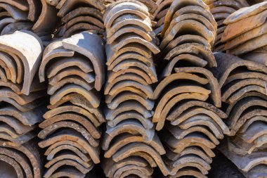 Eski çatı kiremitleri stoklandı ve yeni bir hayat bekliyor. Parlak güneş ışığı. Erikousa Adası, Yunanistan.