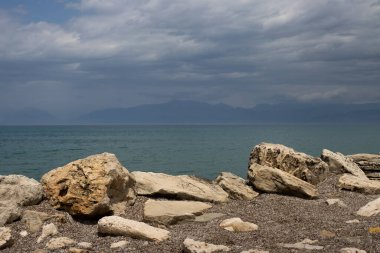 İyon Denizi kıyısındaki kayalar ve taşlar gelgitten kaçıyor. Denizin sakin suları. Yunanistan 'ın Korfu Adası' nın kuzeyindeki Roda 'da bahar.